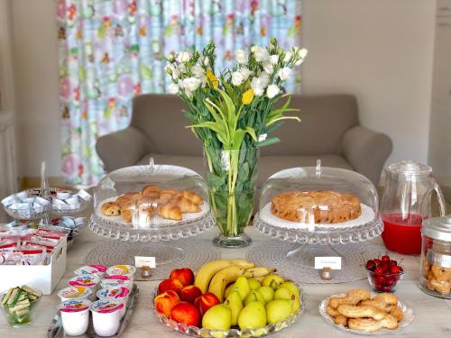 a table with plates of food and a vase of flowers at Pietra Bianca Rooms in Pachino