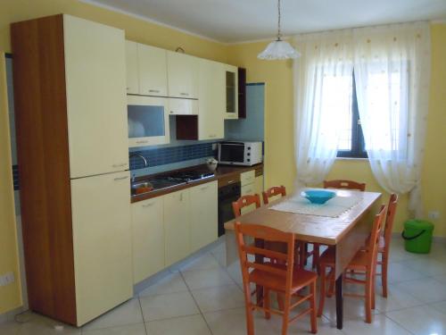Una cocina y un comedor con mesa y sillas. en Villa Rosangela, en Agropoli