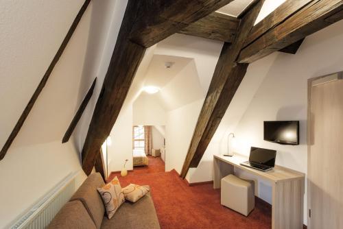 a living room with a couch and a desk with a laptop at Hotel Altes Brauhaus garni in Rothenburg ob der Tauber