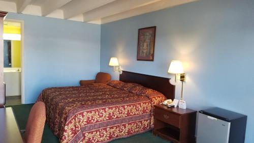 a hotel room with a bed and a television at Scottish Inns Morristown in Morristown