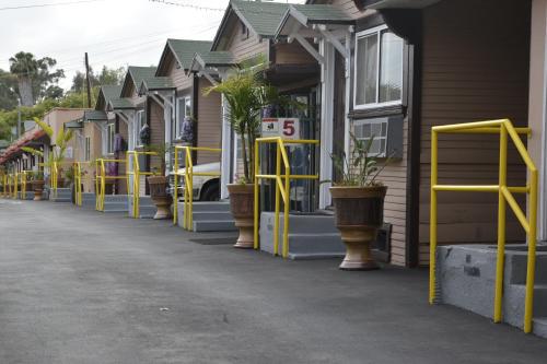 a row of houses with yellow buffers on a street at Lincoln Park Motel in Los Angeles