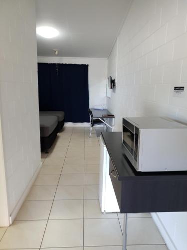 a kitchen with a microwave and a refrigerator at Capricorn Hotel in Blackwater