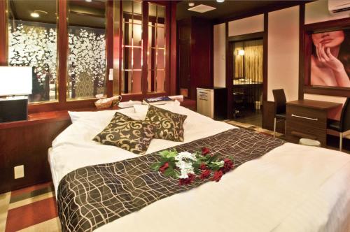 Un dormitorio con una cama grande con flores. en Hotel Hanabi (Love Hotel), en Chikugo