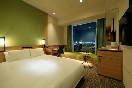a hotel room with a large bed and a window at Candeo Hotels Nara Kashihara in Kashihara