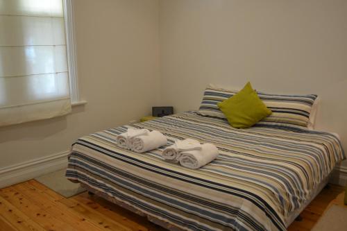 1 dormitorio con 1 cama con toallas en Tin House in Tanunda, en Tanunda