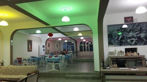 un restaurante con techo verde, mesas y sillas en Nicea Hotel, en Selçuk