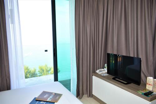 a hotel room with a television and a window at D'Wharf Hotel & Serviced Residence in Port Dickson