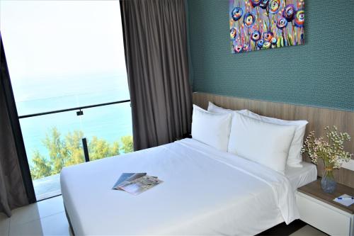 a bedroom with a large white bed with a window at D'Wharf Hotel & Serviced Residence in Port Dickson