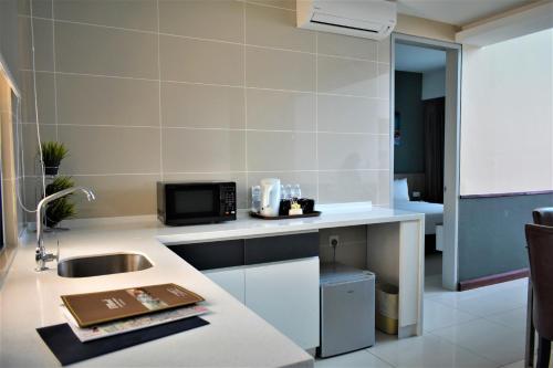 a kitchen with a sink and a microwave at D'Wharf Hotel & Serviced Residence in Port Dickson