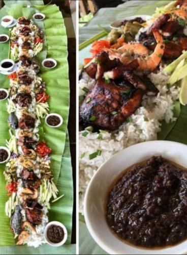 a plate of food with rice and meat and a bowl of sauce at Casitas de Victoria in Nasugbu