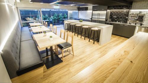 a restaurant with tables and chairs and a kitchen at No. 9 Hotel in Auckland
