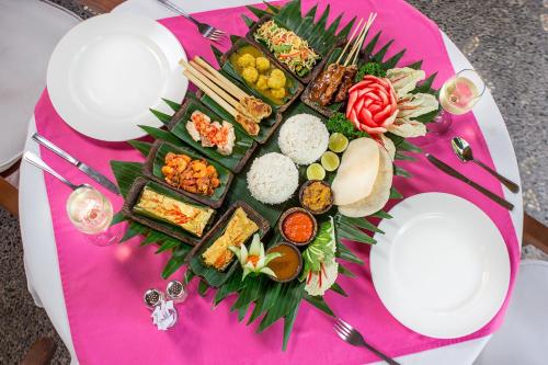 a plate of food on a pink table at Tamukami Hotel in Sanur