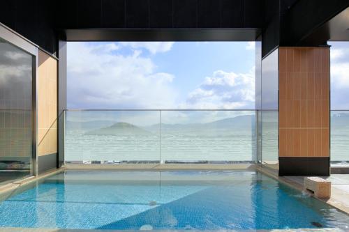 a swimming pool in a building with a view of the ocean at Candeo Hotels Nara Kashihara in Kashihara