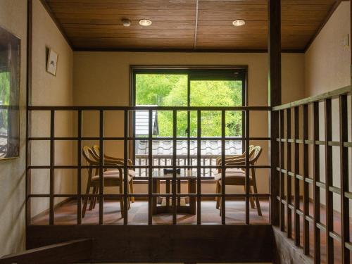a room with two chairs and a table on a balcony at Ryokan Fukinoya in Yufuin