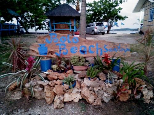 a sign for a beach resort with plants and flowers at Bolo Beach Santorini nearby to Hundred Island in Alaminos