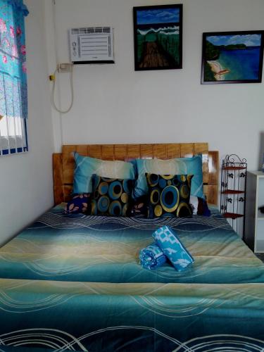 a bedroom with a bed with blue sheets and pillows at Bolo Beach Santorini nearby to Hundred Island in Alaminos