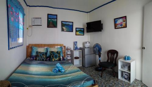 a bedroom with a bed and a desk and a chair at Bolo Beach Santorini nearby to Hundred Island in Alaminos