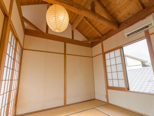 an empty room with a large window and a chandelier at Ryokan Fukinoya in Yufuin