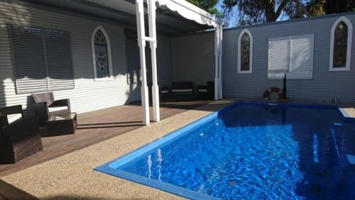 
a blue pool in a backyard with blue walls at The Convent Boutique Accommodation & Cafe in Hay
