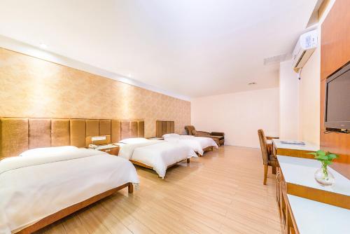 a hotel room with four beds and a flat screen tv at Kaiserdom Hotel Baiyun Airport-24-hour Airport-Free shuttle bus in Huadu
