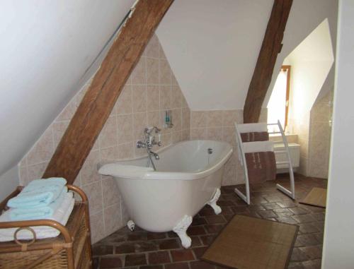 a bathroom with a bath tub in a attic at Chambre d'Hôtes Le Moulin des Landes in Vernou-sur-Brenne