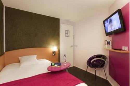 a bedroom with a bed and a tv on the wall at ibis Styles Bourg-en-Bresse Centre in Bourg-en-Bresse