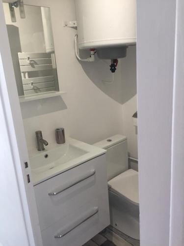 a white bathroom with a sink and a toilet at Ar Kevel in La Baule