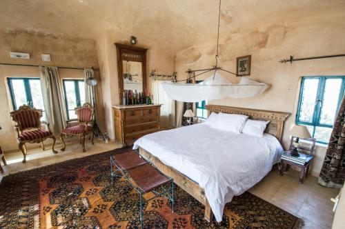 1 dormitorio con 1 cama, mesa y sillas en Beit Al Fannan, en Ţabaqat Faḩl