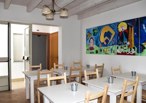 a dining room with tables and a painting on the wall at Al Saliceto Hotel in Patti