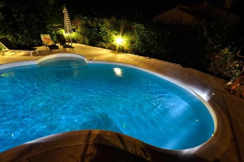 uma piscina num quintal à noite em L'Ecureuil de l'Estérel em Saint-Raphaël