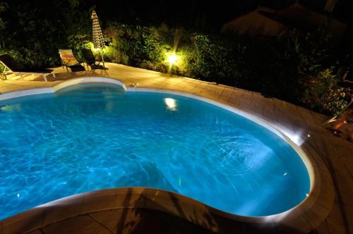 a swimming pool in a yard at night at L'Ecureuil de l'Estérel in Saint-Raphaël