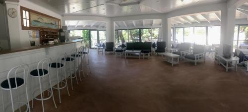 una grande stanza con sedie e un bar con finestre di Lofos Strani a Città di Zante