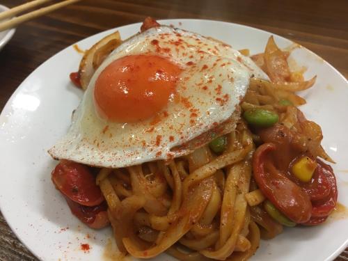 a plate of food with an egg on top of pasta at Jpride Uemachidai Condo in Osaka
