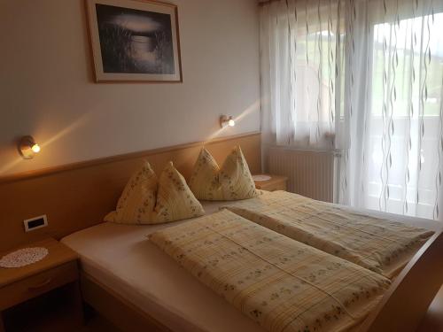 sypialnia z dużym łóżkiem i oknem w obiekcie Ferienwohnung Winklerhof w mieście Maranza