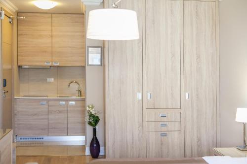 a kitchen with wooden cabinets and a vase of flowers at Apartments Grifone Lux in Herceg-Novi