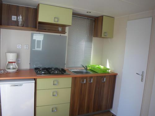 a small kitchen with a sink and a stove at Camping les Auches in Ancelle