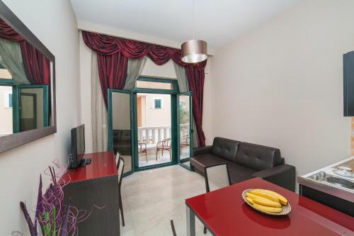a living room with a red table with bananas on it at Apartments Grifone Lux in Herceg-Novi