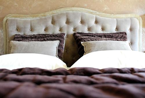 a bed with two pillows on top of it at Hôtel de La Fossette in Le Lavandou