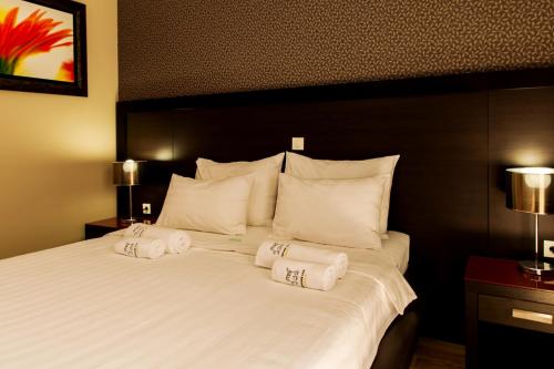 a bedroom with a large white bed with towels on it at Apartments Grifone Lux in Herceg-Novi