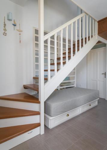 a bedroom with a bed under the stairs at Blue Wave Egli Villa in Symi