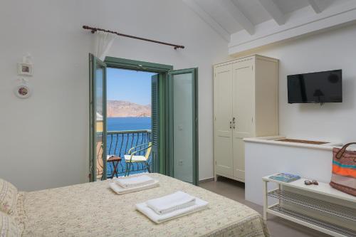 a bedroom with a bed and a view of the ocean at Blue Wave Egli Villa in Symi