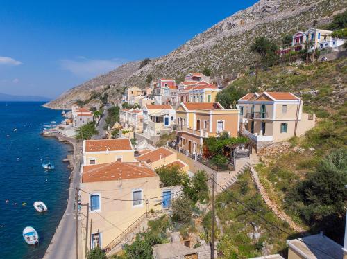 a group of houses on a hill next to the water at Blue Wave Egli Villa in Symi