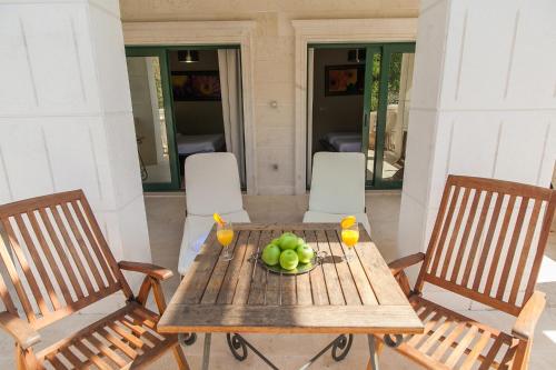 a wooden table with a bowl of fruit on it at Apartments Grifone Lux in Herceg-Novi