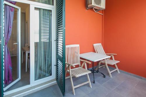 a table and chairs on the porch of a house at Apartments Grifone Lux in Herceg-Novi