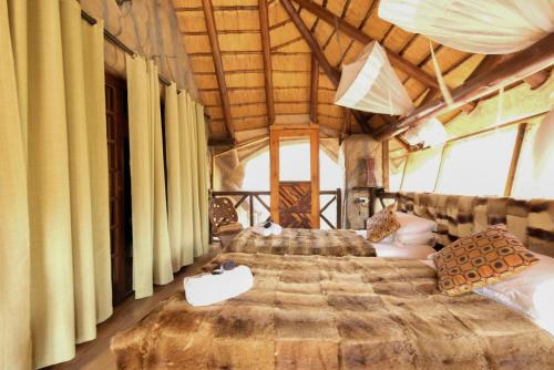 a bedroom with two beds in a tent at Khaya Umdani Guest Houses in Marloth Park