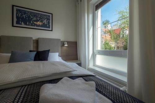 a bedroom with a bed and a large window at Apartamenty Starówka - Riverside II in Szczecin