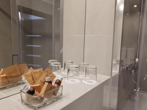 a bathroom counter with glasses and a tray of wine bottles at Apartamenty Starówka - Riverside II in Szczecin