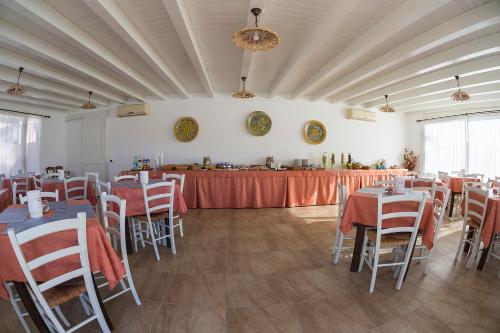 ランペドゥーザにあるB&B Villa Giuliaのテーブルと椅子(赤いテーブルクロス付)のある宴会場
