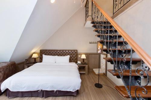 a bedroom with a bed and a staircase at Puli Story House in Puli