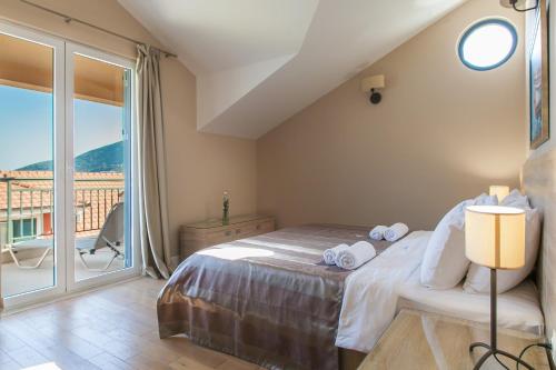 a bedroom with a bed and a balcony at Apartments Grifone Lux in Herceg-Novi